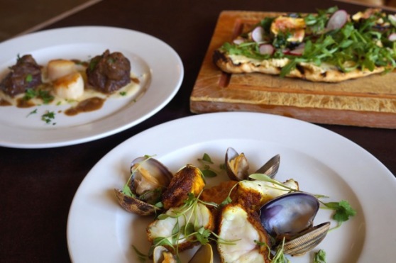 Spiced monkfish with puff pastry biscuit, clams & sweet potato; Coriander flatbread with hummus, rocket, roast fig, pomegranate & gremolata; and Braised pigs cheeks with seared scallops, fennel & apple puree